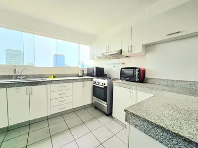 a kitchen with white cabinets and a stove top oven at E Tourist Zone Wifi Pro 2 Smart TV 3B 1206 in Lima