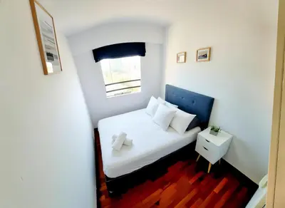 a small bedroom with a white bed and a window at E Tourist Zone Wifi Pro 2 Smart TV 3B 1206 in Lima