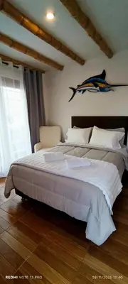 a bedroom with a large bed with a shark on the wall at Hospedaje Vientos in Paracas