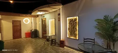 a room with a glass table and chairs and a wall at Hospedaje Vientos in Paracas