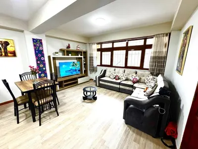 a living room with a couch and a table and a tv at Aitanas House Huancaro in Cusco