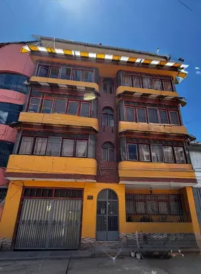 a tall building with many windows on it at Aitanas House Huancaro in Cusco