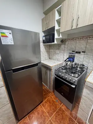 a kitchen with a stove and a stainless steel refrigerator at Aitanas House Huancaro in Cusco