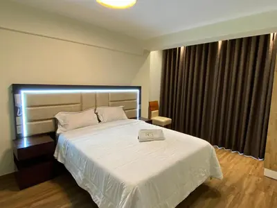 a bedroom with a large white bed and a window at Hotel Sonccollay in Huancayo