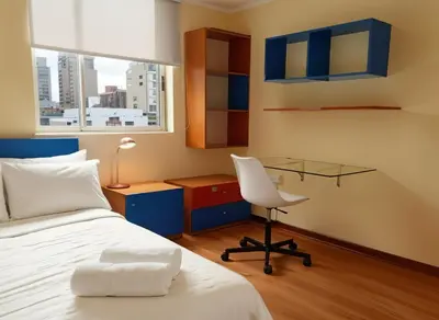 a bedroom with a bed and a desk and a chair at E Green View Parking Wifi Pro 4B 904 in Lima