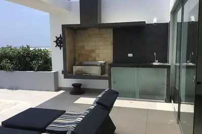 a living room with a couch and a kitchen at Casa de playa 1era fila cala del mar in Salitre