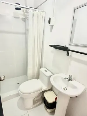 a white bathroom with a toilet and a sink at Casa playa Paracas-Pisco in Pisco