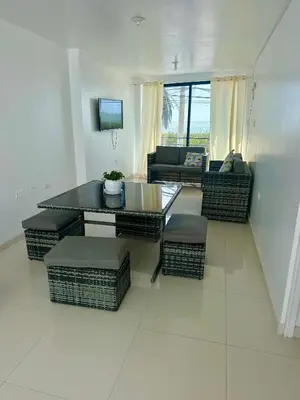 a living room with a table and wicker chairs at Casa playa Paracas-Pisco in Pisco