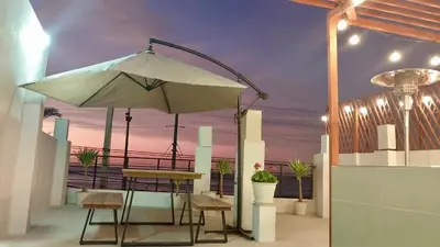 a patio with a table and an umbrella at Casa playa Paracas-Pisco in Pisco