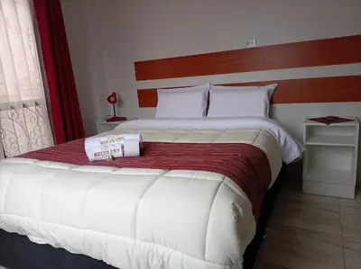 a bedroom with a large white bed with a red blanket at Belys inn in Cusco