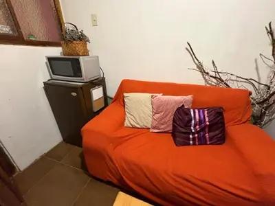 an orange couch with two pillows on it in a room at super cute affordable mini apt, san Blas in Cusco