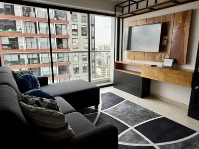 a living room with a couch and a flat screen tv at Departamento Vizuale in Lima