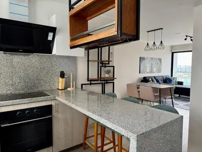 a kitchen with a counter top and a living room at Departamento Vizuale in Lima