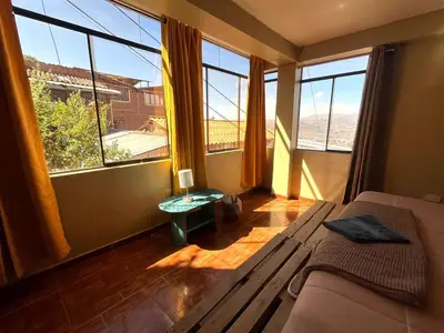 a living room with a couch and large windows at New colorful & artsy home, fam perfect, great wifi for working in Cusco