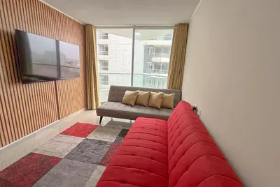 a living room with a couch and a window at Dpto exclusivo en San Miguel con piscina y gym in Lima