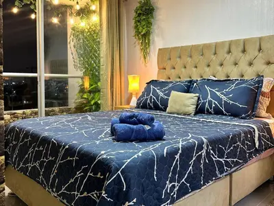 a large bed with a blue and white comforter at Dpto exclusivo en San Miguel con piscina y gym in Lima
