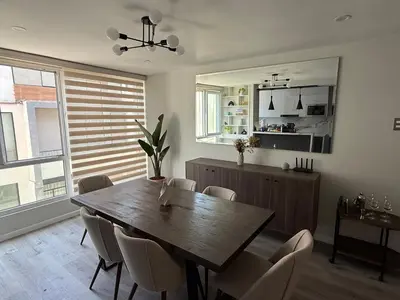 a dining room with a wooden table and chairs at Modern and Cozy appartment in Lima