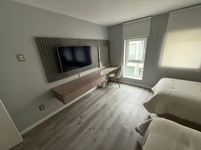 a bedroom with a flat screen tv on the wall at Modern and Cozy appartment in Lima