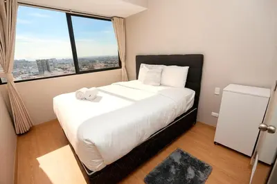 a bedroom with a large bed with a large window at Perfect Balance Rest and Work Study Oceanfront in San Antonio