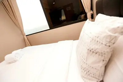 a bed in a room with a mirror and white sheets at Perfect Balance Rest and Work Study Oceanfront in San Antonio