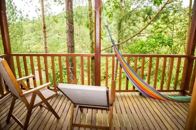 a porch with a hammock and a chair on a deck at Altares de Oxapampa in Oxapampa