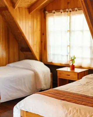 a bedroom with two beds and a window at Altares de Oxapampa in Oxapampa