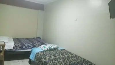 a room with two beds in a room at Hospedaje El Encanto in Huancayo