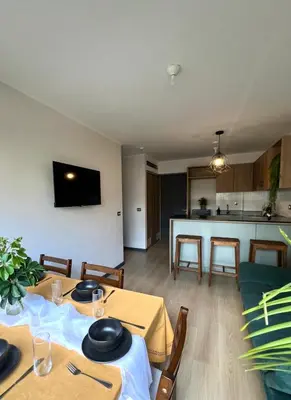 a living room with two tables and a kitchen at Departamento 9 Personas San Isidro in Lima