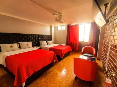 a hotel room with two beds and a chair at Hostal Paris 3 Visita Lima con excelente ubicación, wifi gratis y vistas en in Lima