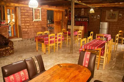 a restaurant with wooden tables and chairs in a room at Casa rústica Pumayalli in Urubamba