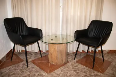 two black chairs and a glass table in a room at Xaxa Lodge in Tarma