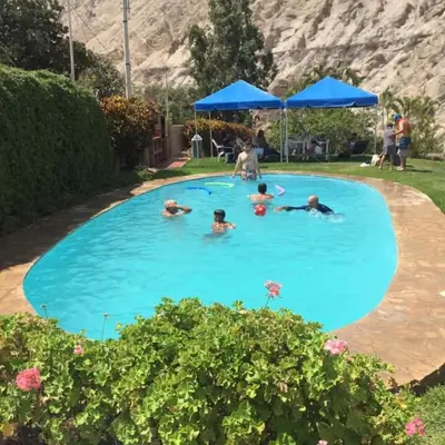a group of people swimming in a swimming pool at San Jerónimo River Lodge in Lunahuaná