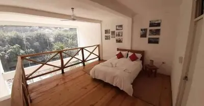 a bedroom with a bed and a large window at San Jerónimo River Lodge in Lunahuaná