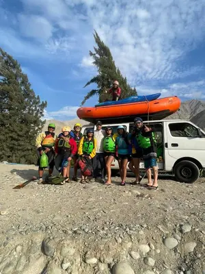 a group of people standing next to a truck with a raft at San Jerónimo River Lodge in Lunahuaná