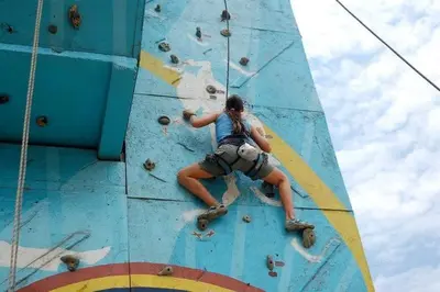 a woman climbing on a climbing wall at San Jerónimo River Lodge in Lunahuaná