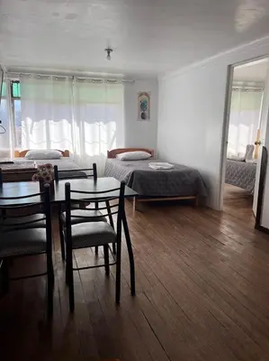 a living room with two beds and a table and chairs at Apartamento Salkantay con vista al Cusco in Cusco
