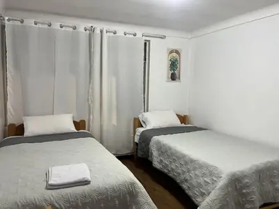 a room with two beds and a window at Apartamento Salkantay con vista al Cusco in Cusco