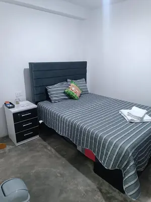 a bedroom with a bed and a nightstand with a bed sidx sidx at IN FRONT OF THE NEW AIRPORT Hospedaje A y C - Taxi Free - Airport - Apartment Includes breakfast in Lima