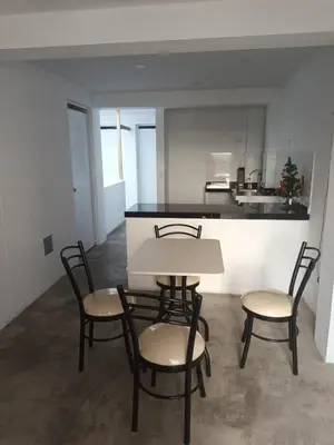 a table and chairs in a room with a kitchen at IN FRONT OF THE NEW AIRPORT Hospedaje A y C - Taxi Free - Airport - Apartment Includes breakfast in Lima