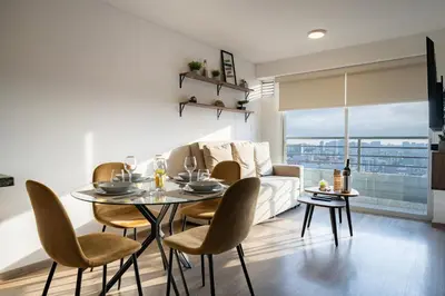 a living room with a table and chairs and a couch at Centric Apartments by Vibrant in Lima
