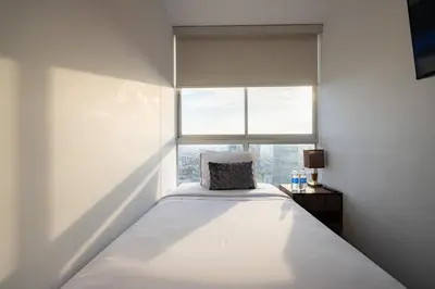 a bed in a white room with a window at Centric Apartments by Vibrant in Lima