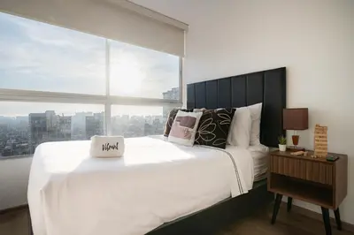 a bedroom with a large white bed with a large window at Centric Apartments by Vibrant in Lima