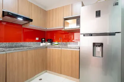 a kitchen with red cabinets and a refrigerator at Platino Apartments by Vibrant in Lima