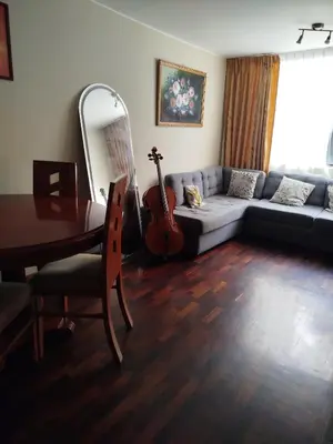 a living room with a couch and a table and a guitar at Like a Home - Barranco in Lima