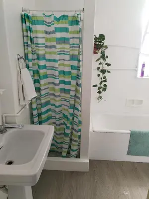 a bathroom with a shower curtain next to a sink at Amplio Departamento 2 dormitorios in Lima