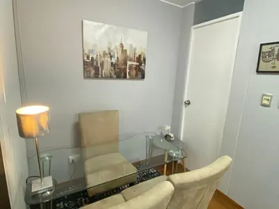 a living room with a glass table and a chair at Duplex penthouse in Miraflores with terrace in Lima