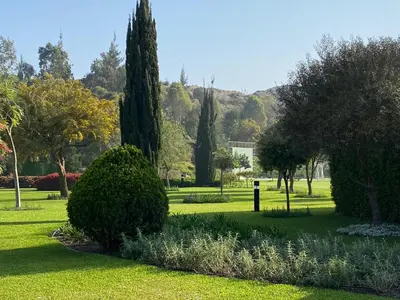 a park with trees and bushes in the grass at Casa de Campo en Cieneguilla in Cieneguilla