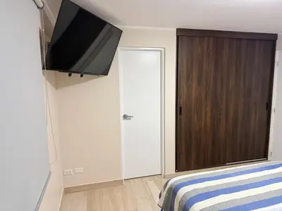 a bedroom with a flat screen tv and a bed at Minidepartamento en Miraflores in Lima