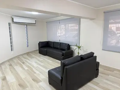 a living room with a black couch and a chair at Minidepartamento en Miraflores in Lima