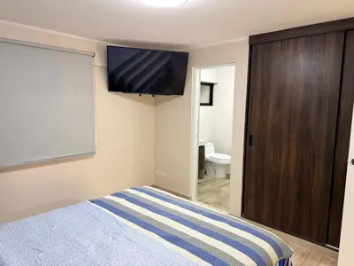 a bedroom with a bed and a flat screen tv at Minidepartamento en Miraflores in Lima